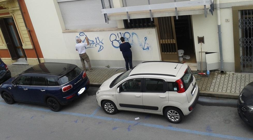 Ripuliscono la strada imbrattata di scritte 