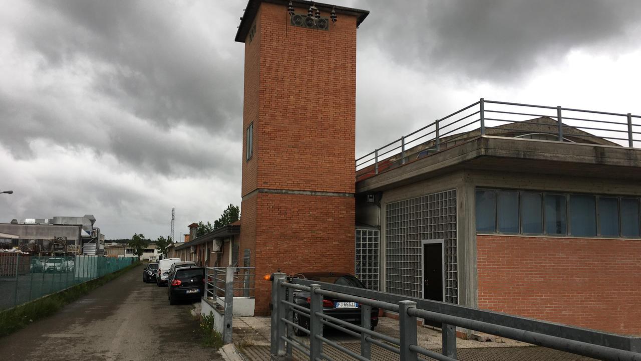 La strada dove ha sede l’azienda presa di mira dai banditi, a destra il logo della ditta (Foto Silvi)