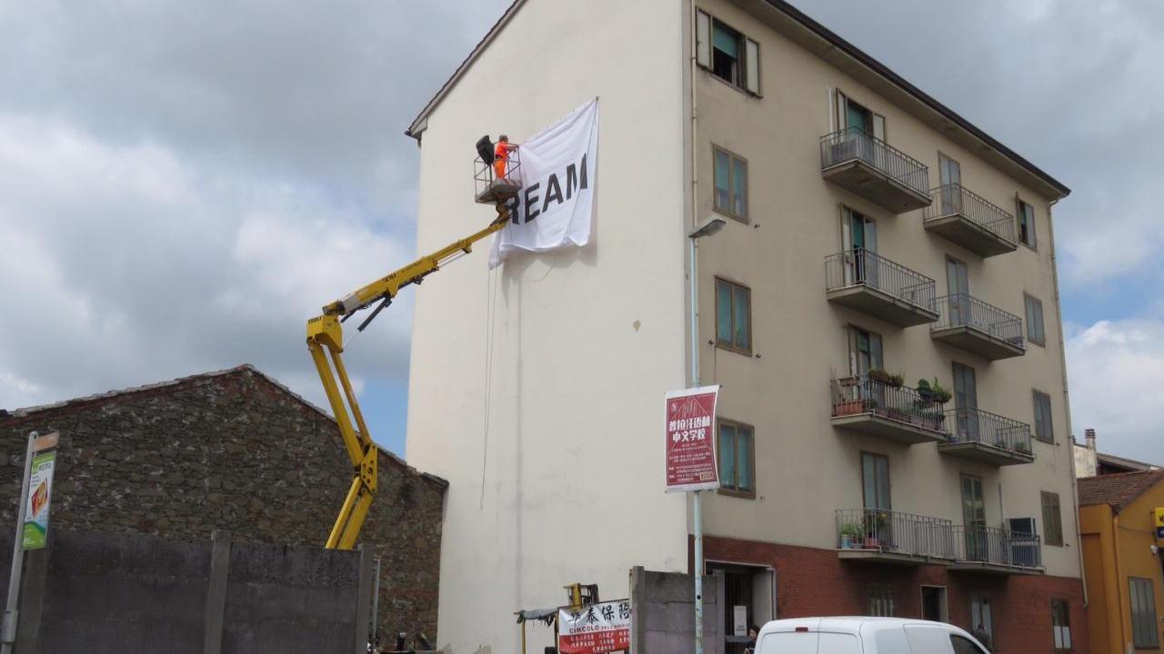 L'affissione di un manifesto su di un palazzo (foto Sproviero-Batavia)