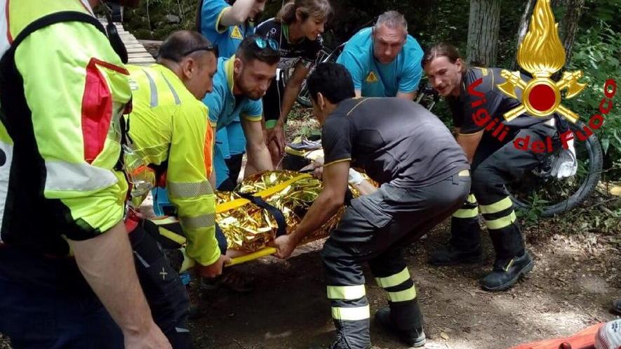 Ciclista cade giù da un ponticino in mezzo al bosco