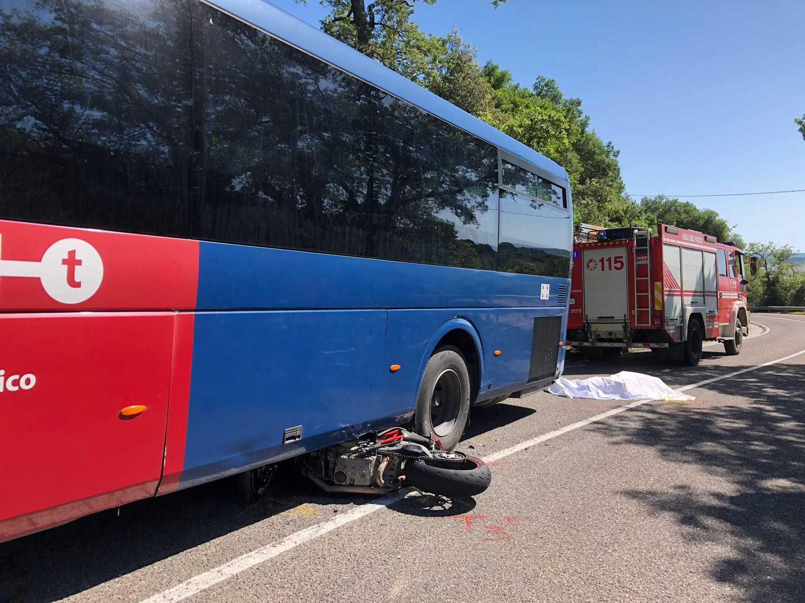 La moto incastrata sotto il pullman e poco distante il corpo del motociclista