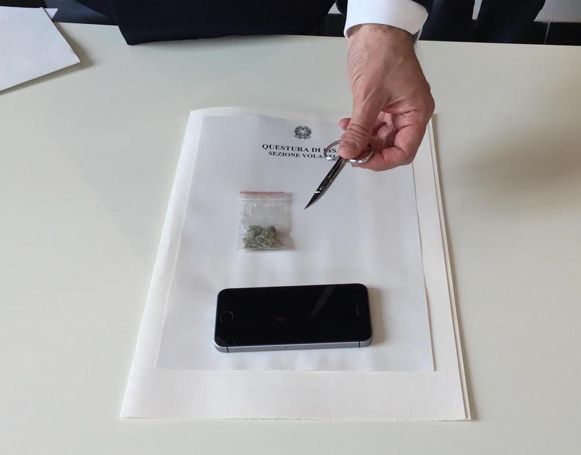 L'iPhone rubato e la marijuana sequestrata, con le forbicine usate per ferire la vittima tenute in mano dal capo di gabinetto della questura pisana, Paolo Pizzimenti