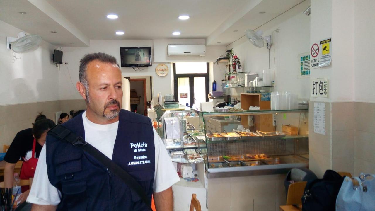 Un poliziotto durante l'ispezione nella tavola calda cinese