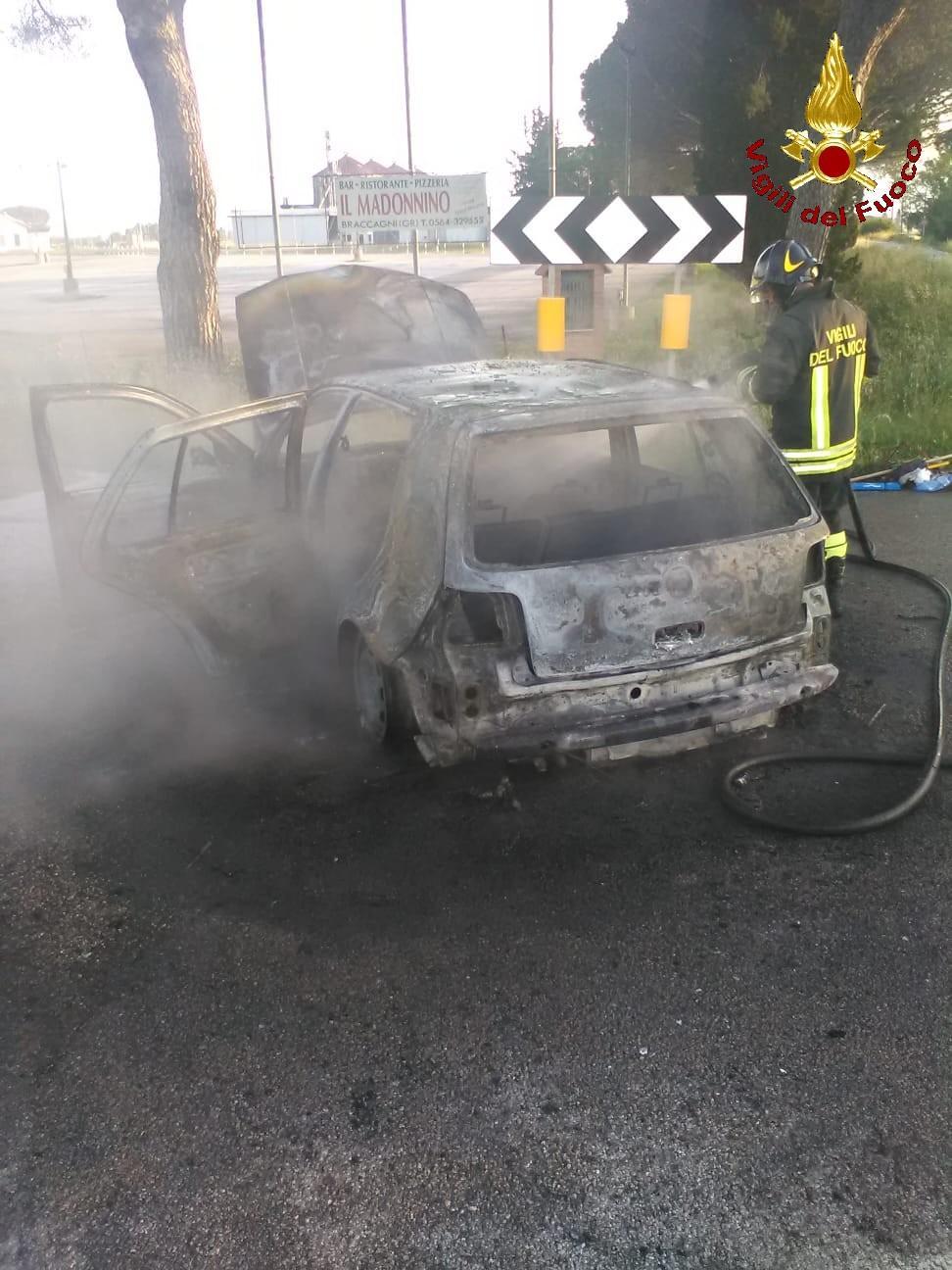 L'auto distrutta dal fuoco e l'intervento dai vigili del fuoco (foto Centro documentazione dei vigili del fuoco)