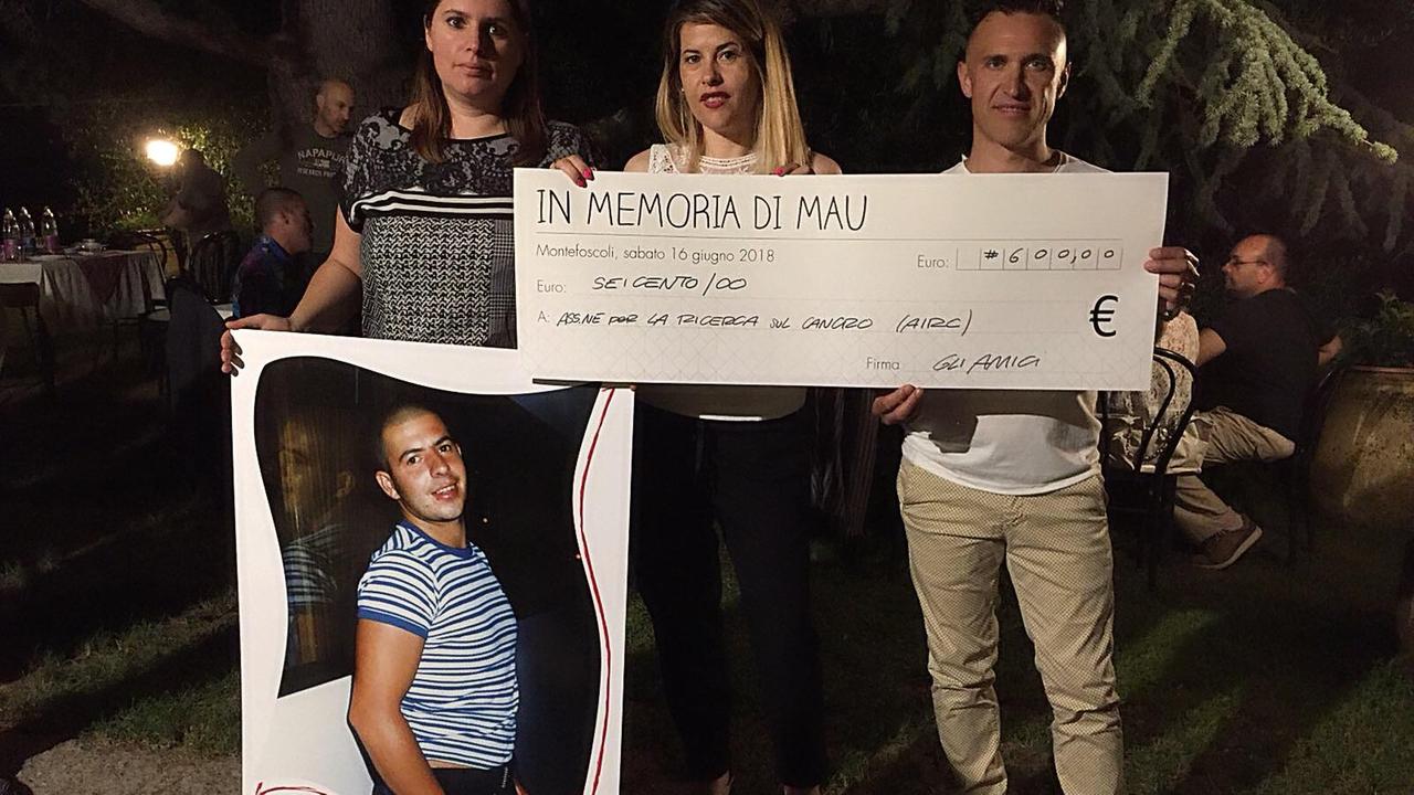 Gli organizzatori della cena per Mau e l’assegno del denaro raccolto per l’Airc