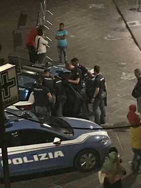 Nella foto scattata da un lettore la polizia blocca l'albanese fuori dal bar di via Carducci