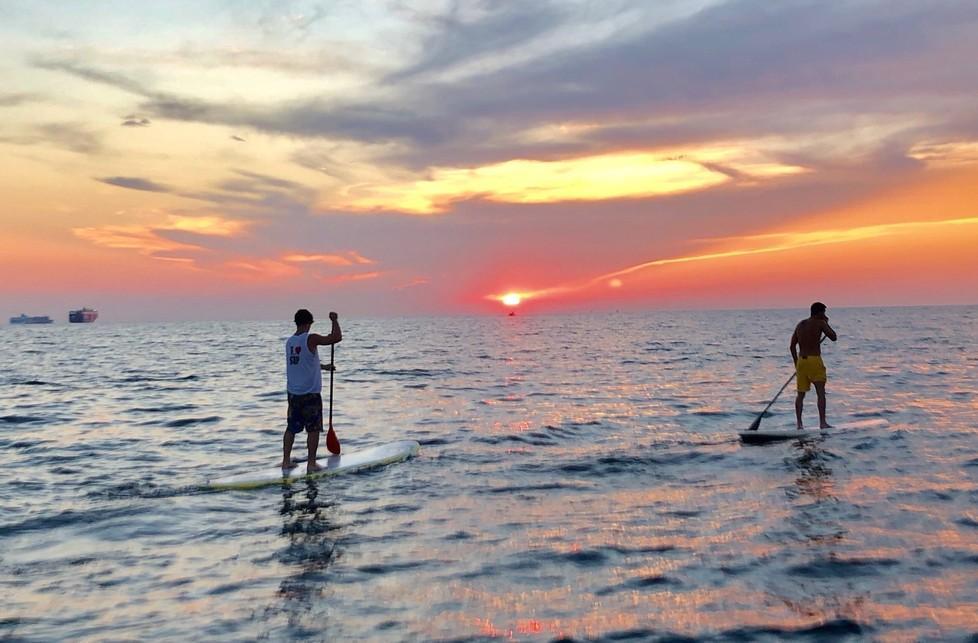 Al largo con il sup mentre il sole va giù