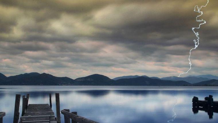 La tempesta di fulmini passa sopra al lago