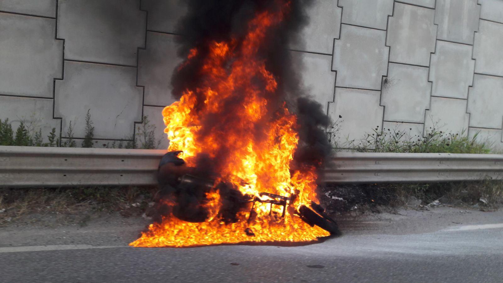 Scooter in fiamme lungo la strada