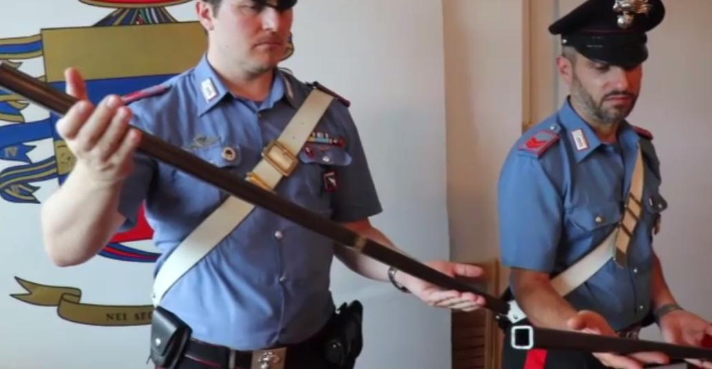 I carabinieri mostrano le spranghe sequestrate ai due nigeriani
