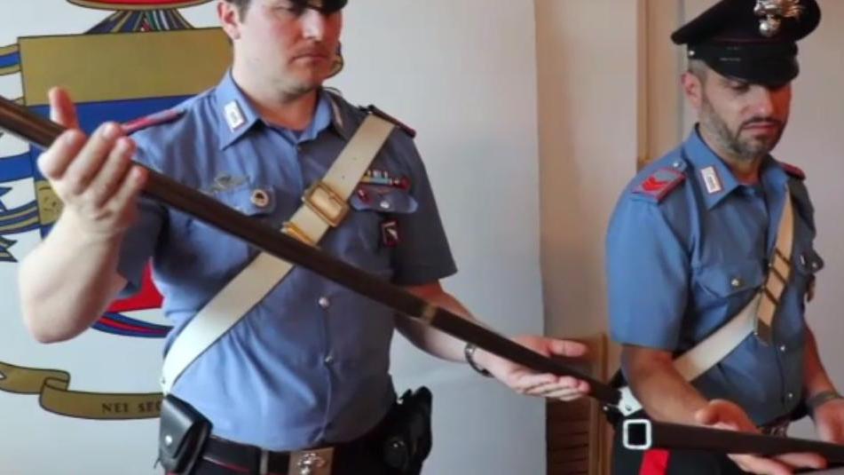 I carabinieri mostrano le spranghe sequestrate ai due nigeriani