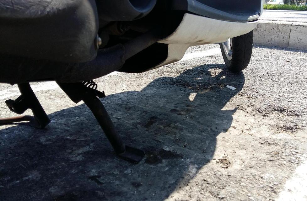 Maxibuche nell’asfalto dei posti per gli scooter