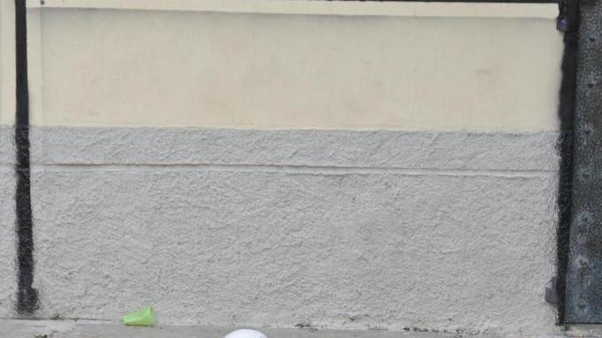 Spara a tre ragazzi che giocano a calcio in piazza