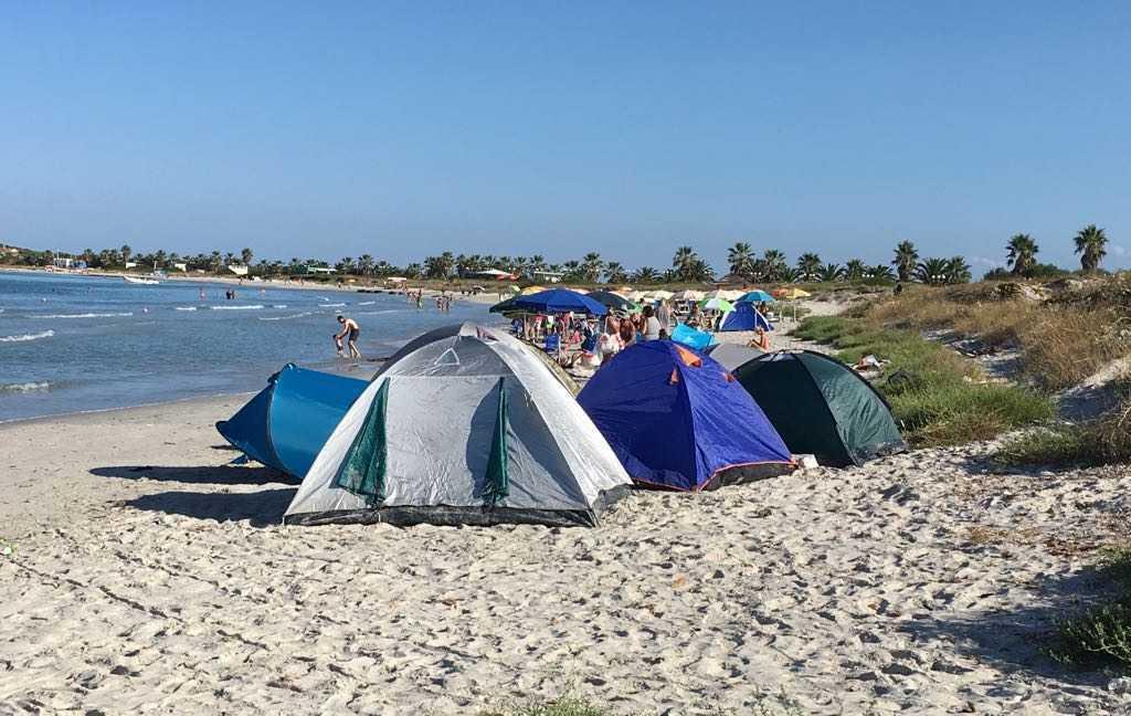 Con le auto sulle dune e le tende in spiaggia 