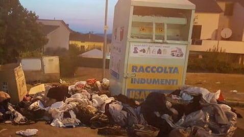 Rifiuti e degrado intorno ai cassonetti di raccolta degli abiti
