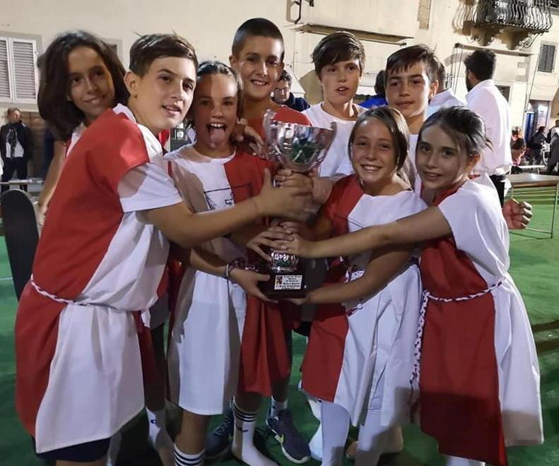 I ragazzi del Rione Santa Maria esibiscono la coppa vinta nel gioco della palla al paniere