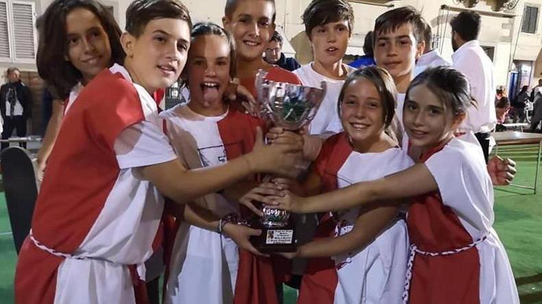 I ragazzi del Rione Santa Maria esibiscono la coppa vinta nel gioco della palla al paniere