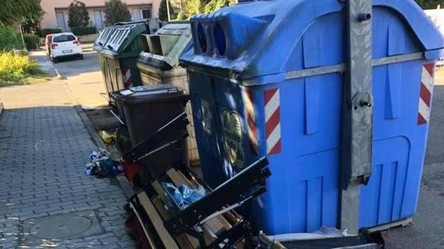 Vecchi arredi ammassati accanto al cassonetto