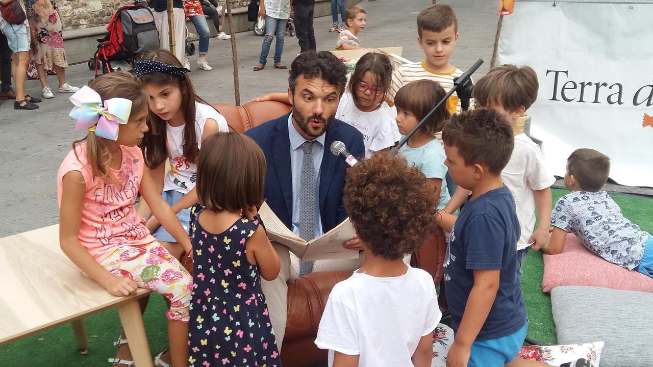 Il sindaco Matteo Biffoni mentre legge le fiabe in piazza