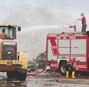 Sopra e a destra, due momenti dell’incendio in corso ai rifiuti stoccati all’interno della Lonzi Metalli