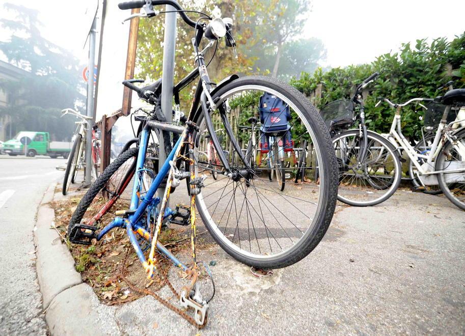 Una bicicletta saccheggiata dai ladri di pezzi di ricambio davanti alla stazione