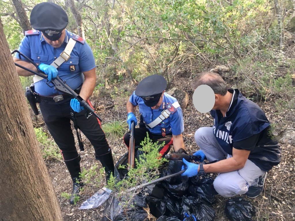 I carabinieri disseppelliscono il borsone con le armi (foto Mario Rosas)