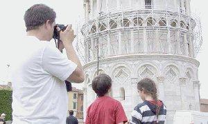 Turisti sotto la Torre, è visibile il ponteggio per la pulitura del marmo