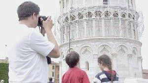 Turisti sotto la Torre, è visibile il ponteggio per la pulitura del marmo