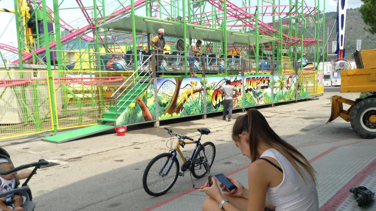 Una ragazza tra le giostre del luna park (foto d'archivio)