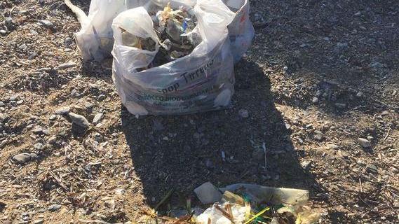 I turisti ripuliscono la spiaggia di Malpasso coperta di plastica