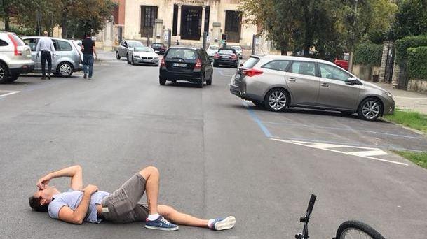 Il giovane steso a terra dopo essere stato falciato dal pirata della strada