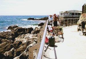 Alcuni bagnanti cercano di raggiungere gli scogli