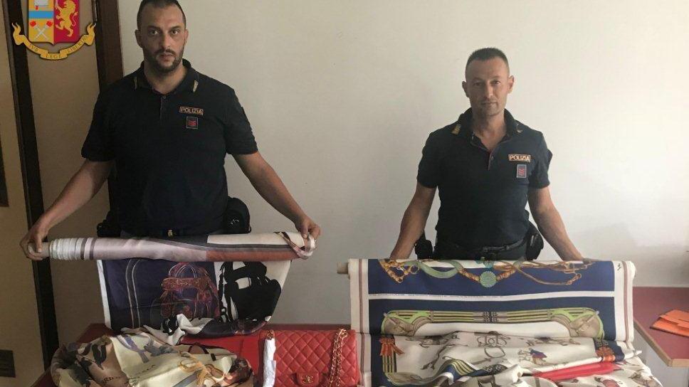 Gli agenti della Polstrada mostrano i tessuti taroccati sequestrati