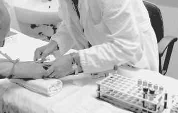 Un’infermiera preleva sangue a una paziente