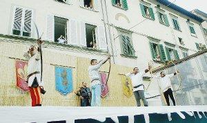 Arcieri in gara e, a lato, il Palio disegnato da Ida Biondi