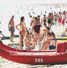Sopra, turisti al mare In alto, il cartellone pubblicitario