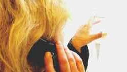 Una donna al telefono mentre guarda alla finestra Immagine simbolo dello stalking