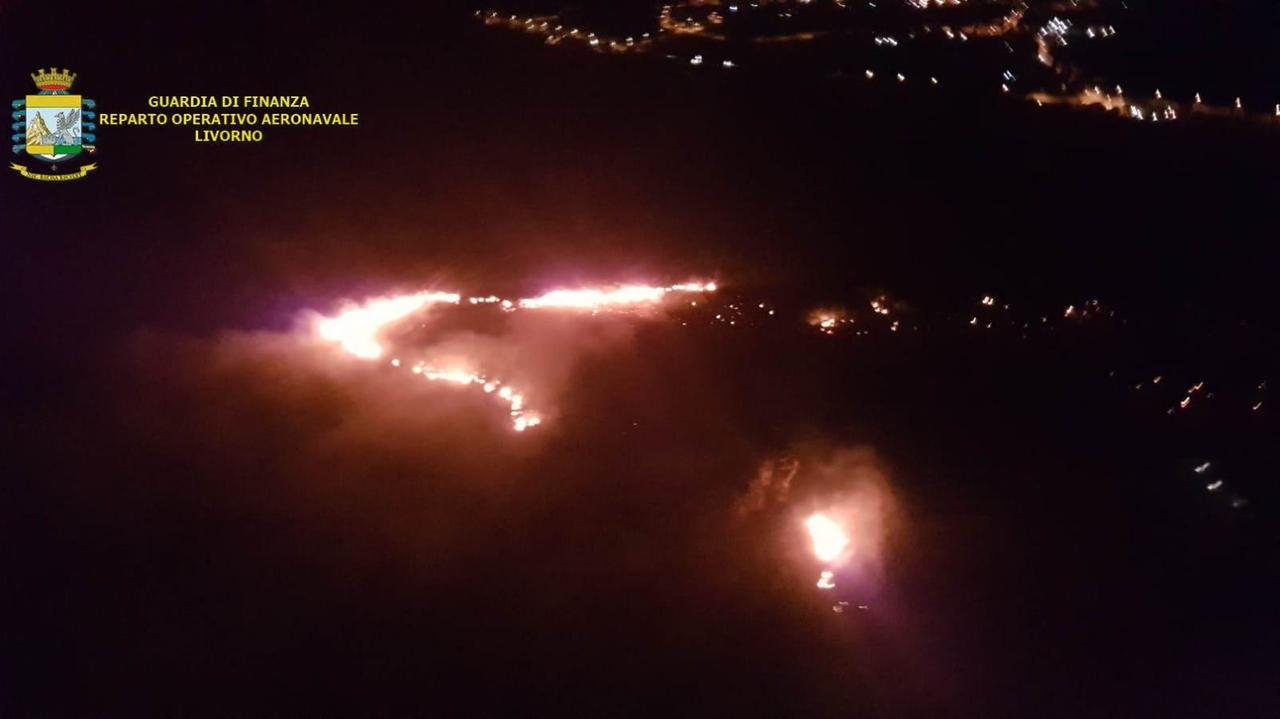 Una veduta dall'alto dell'incendio nell'area pisana del reparto operativo aeronavale di Livorno della Guardia di Finanza (sezione aerea di Pisa). Il reparto è comandato dal colonnello Amedeo Antonucci, la sezione aerea è guidata dal maggiore Massimo Anedda. Nella tarda serata le fiamme si sono ulteriormente estese ad altri punti