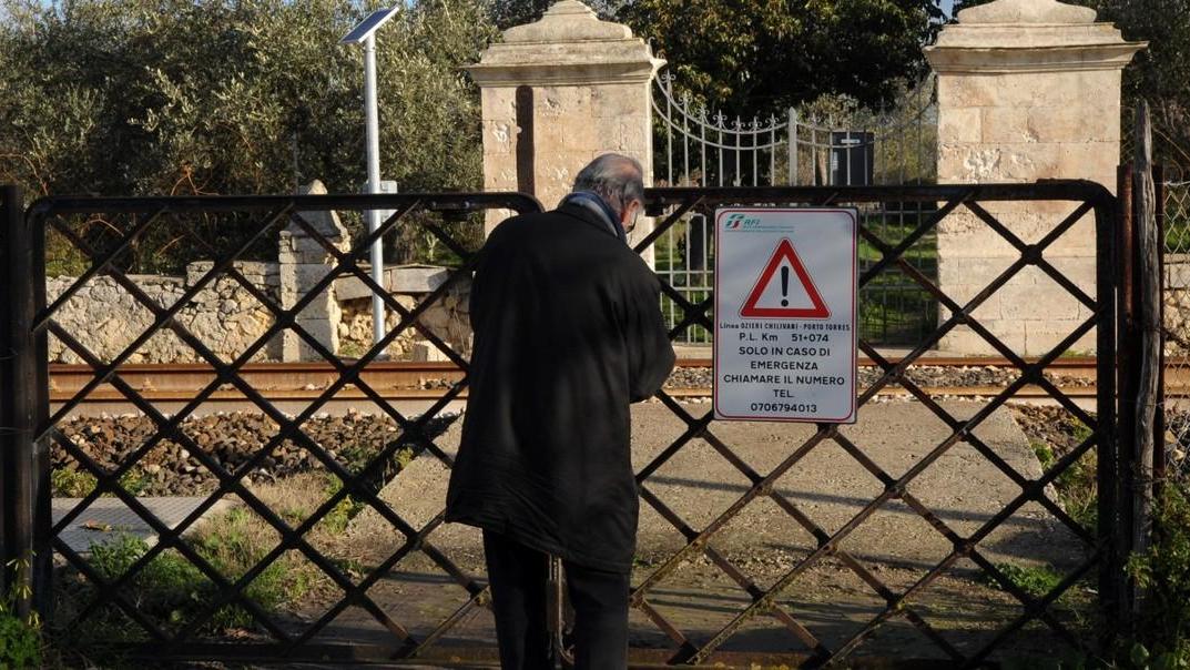 Pietrino Sanna, uno dei proprietari dei terreni a San Giorgio con vista sulle rotaie, apre il cancello per rientrare a casa