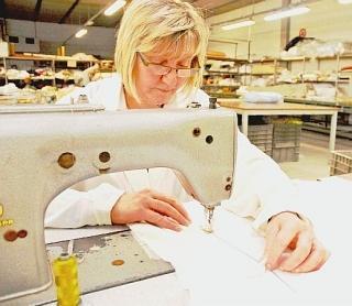 Un’operaia al lavoro in una ditta di biancheria