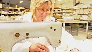 Un’operaia al lavoro in una ditta di biancheria