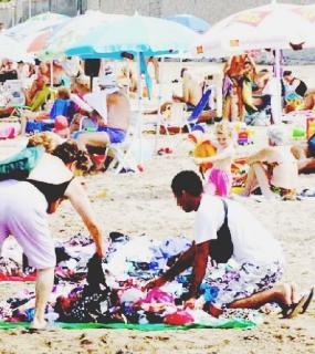 Un ambulante vende vestiti sulla spiaggia