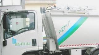 Sopra un mezzo dell’Asmiu A destra i contenitori del porta a porta al centro della polemica