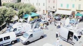 Bagnone: i numerosi camion per i collegamenti via satellite delle emittenti televisive. A destra, la festa in paese