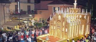 A sinistra il Dolcione a forma di Duomo di Milano mentre viene trainato