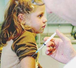 Un medico somministra il vaccino a una bambina
