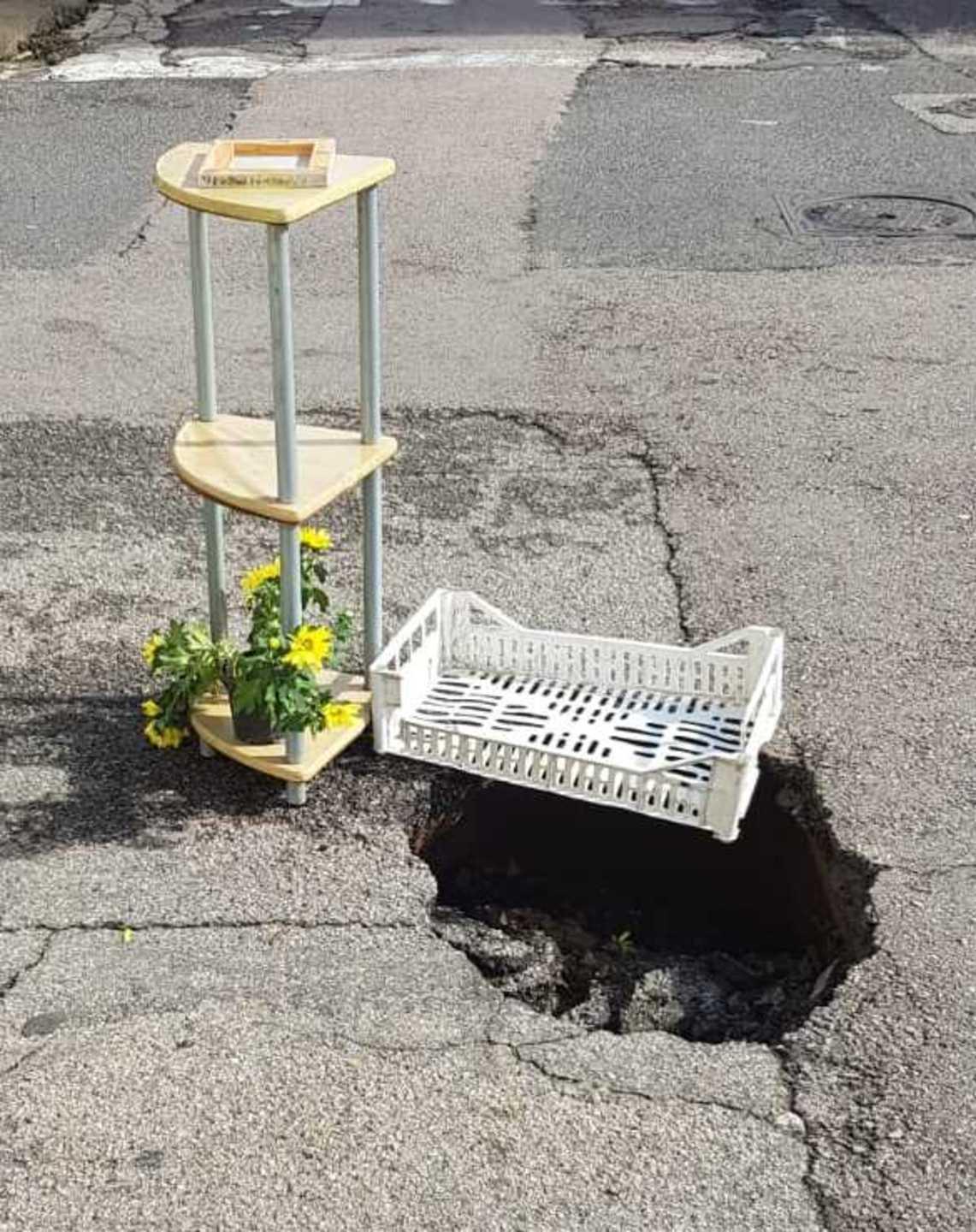 Vasi di fiori e cassette di frutta per una buca in via Romagna
