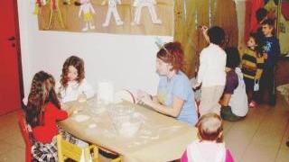 Bimbi e un’operatrice in una scuola materna