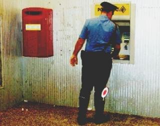 Un carabinierie mentre effettua un controllo a un bancomat