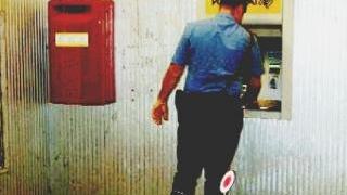 Un carabinierie mentre effettua un controllo a un bancomat